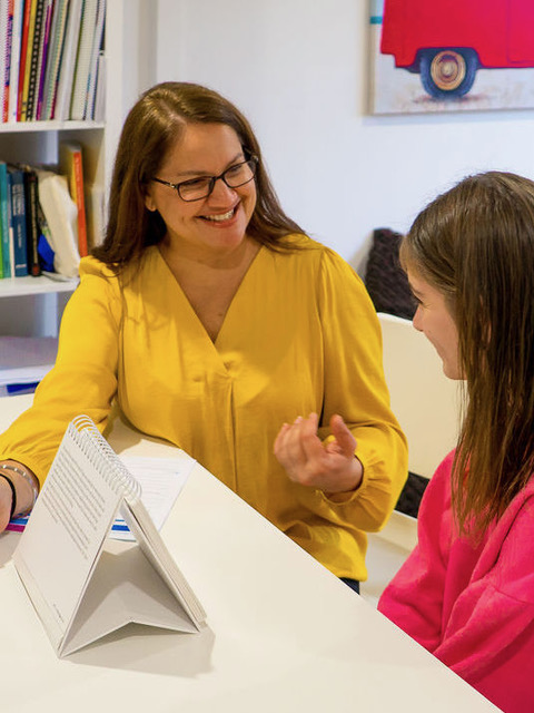 Sim laughing with a young child during an early-words session